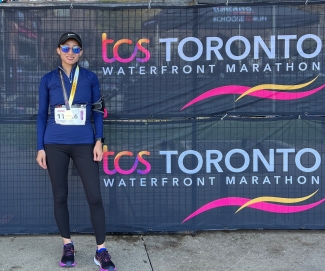 Woman with medal at Toronto Waterfront Marathon sign