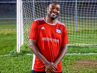 Canadian blood services manager in soccer uniform in front of soccer net