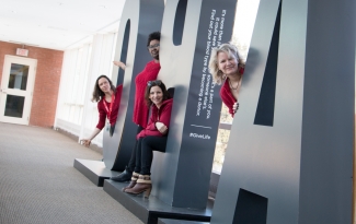 Élodie Guitteaud and her colleagues pose by a sign at Canadian Blood Services head office in Ottawa.