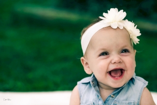 Image of baby blood recipient Madison Lewis sitting outside smiling