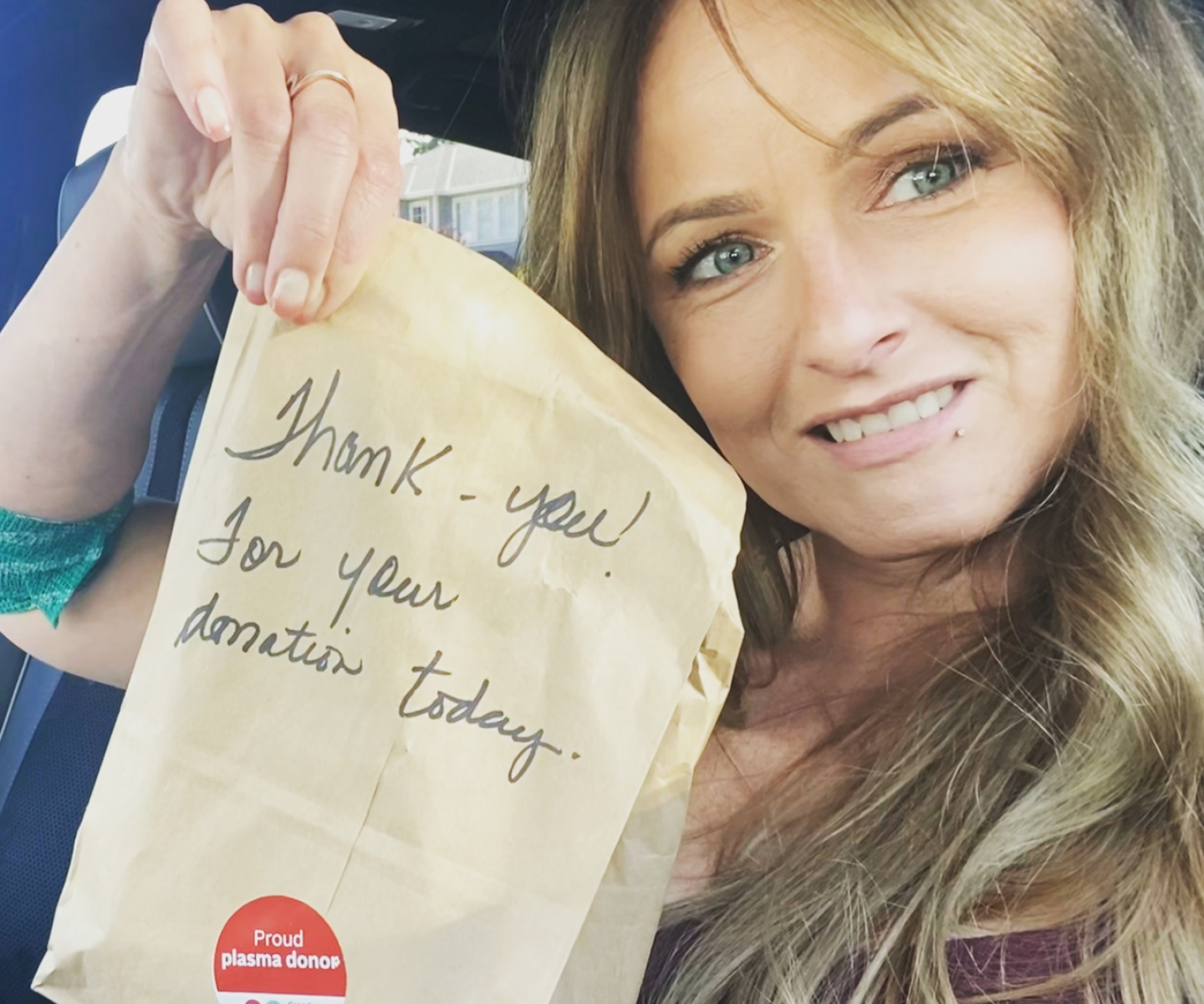 woman showing thank you note for donating plasma