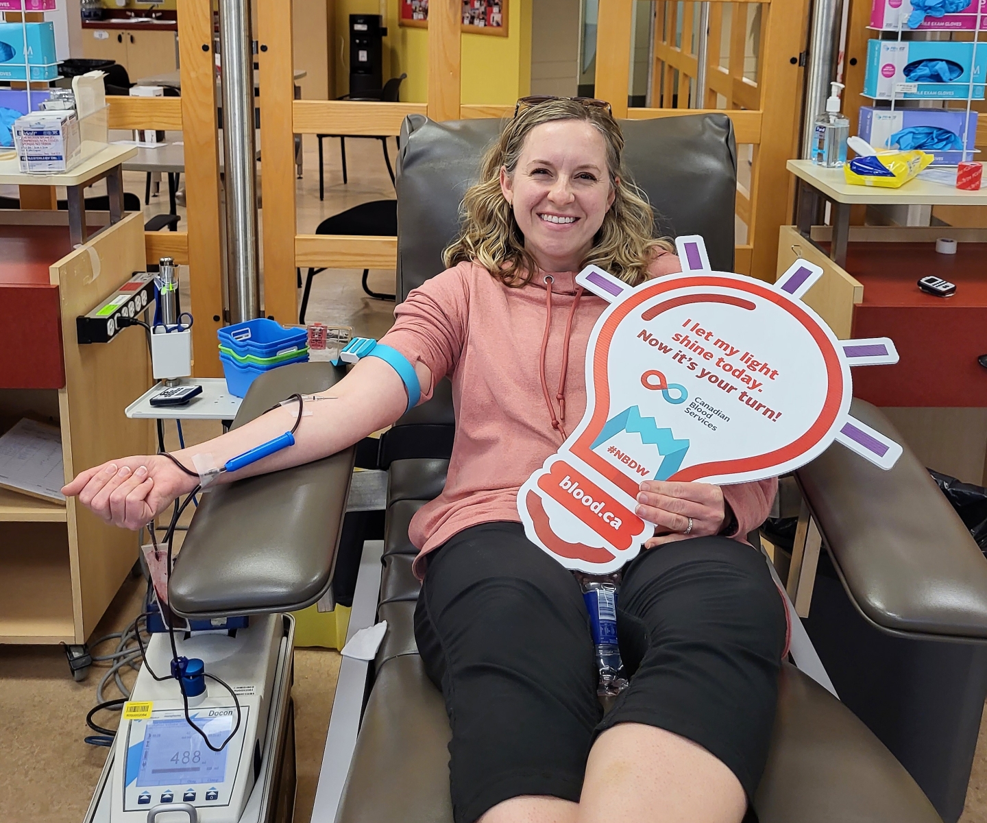 Blood donor in bed with Shine A Light sign