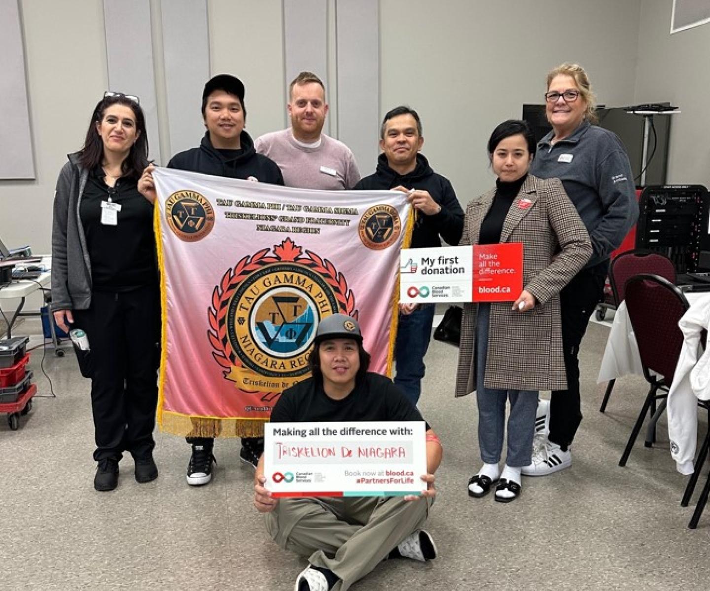 Group of first time blood donors holding signs