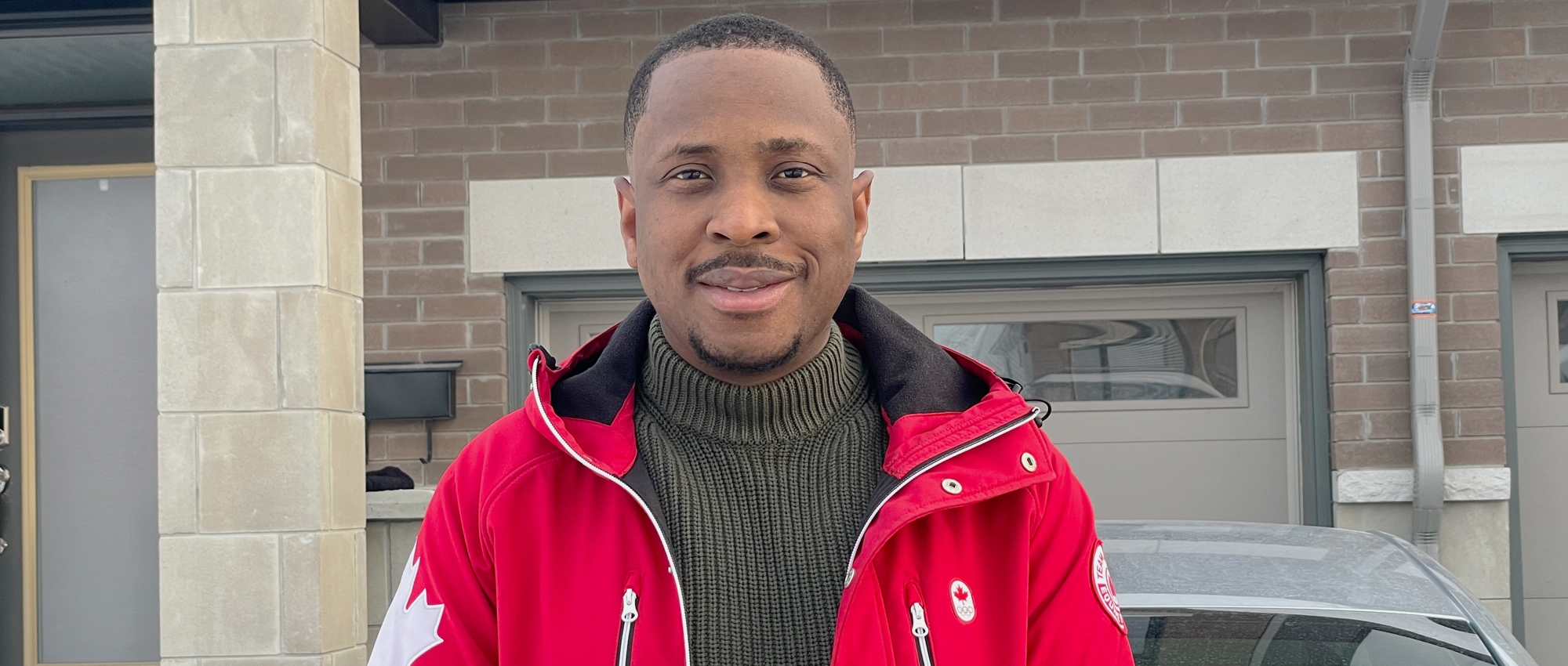 Akintunde Adeniyi, a Black employee at Canadian Blood Services, stands in front of his bricked house. Akintunde wants to see his organization’s diversity and inclusion work continue in 2021 with the same momentum it did last year. 