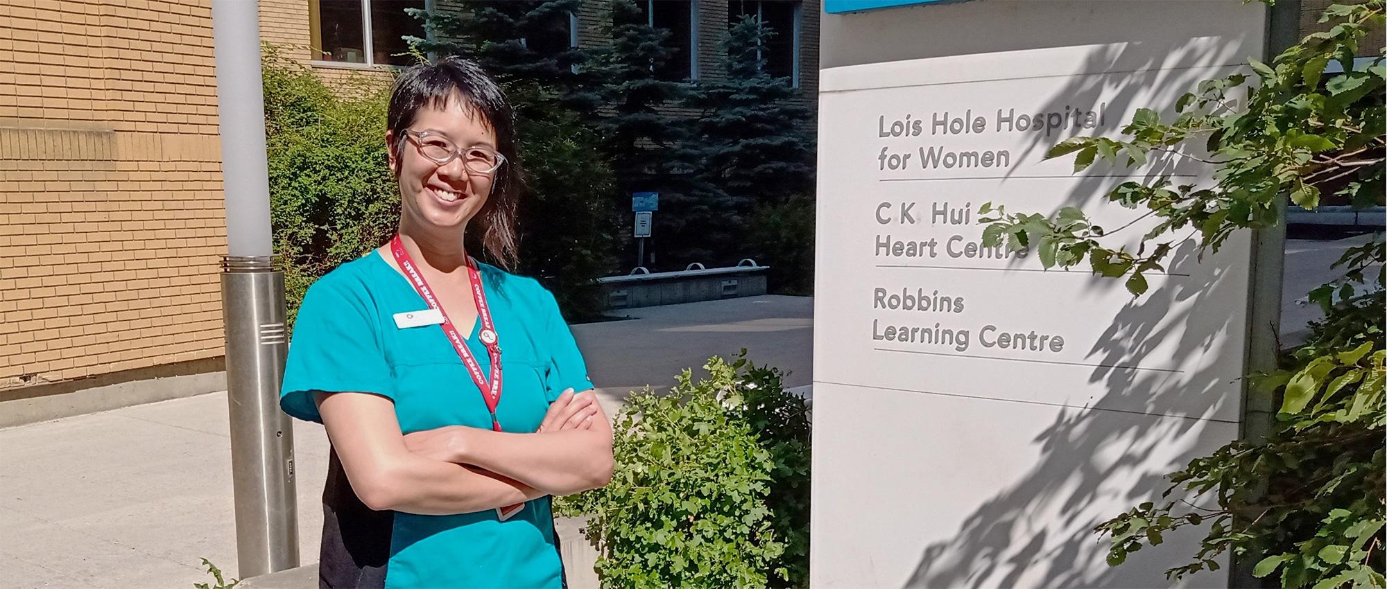 A cord blood specialist in scrubs on a hospital campus in Edmonton.