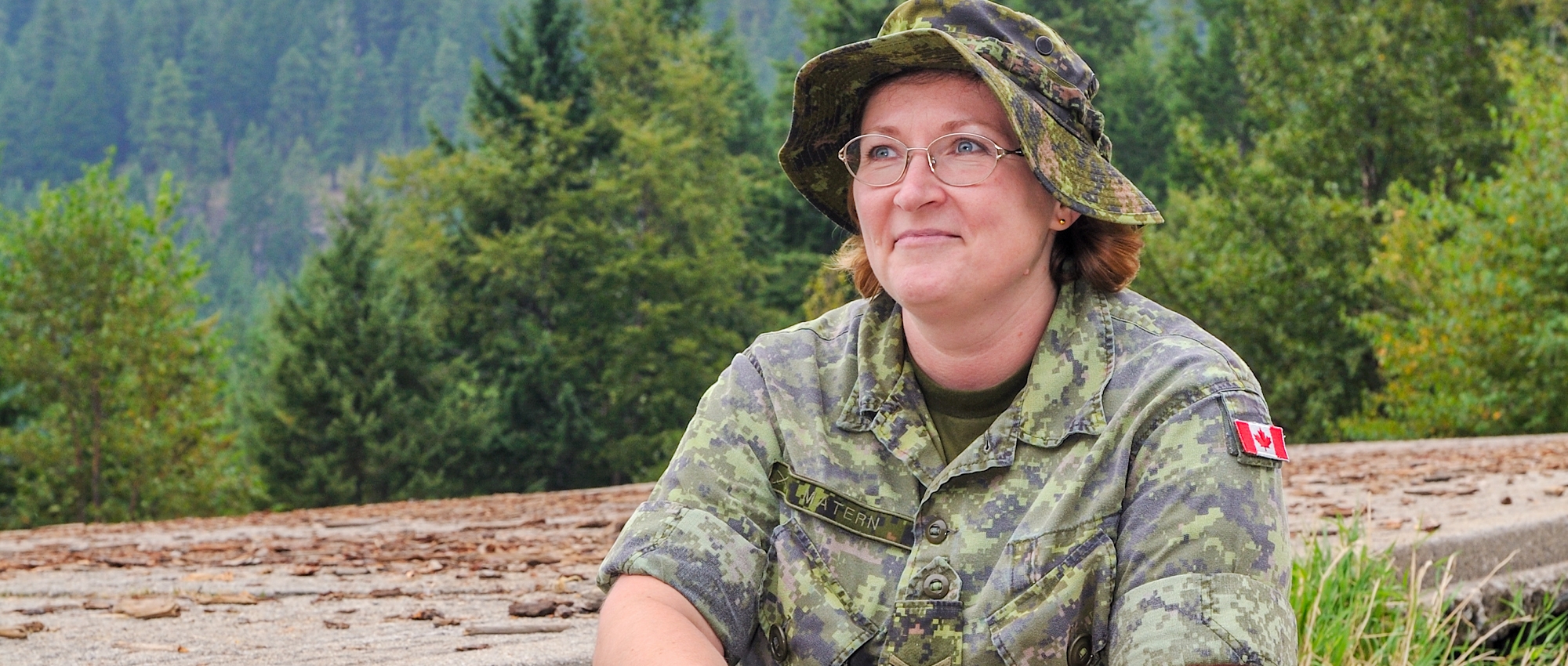 Image of blood donor Corporal Laura Matern sitting on a rock wearing full military uniform