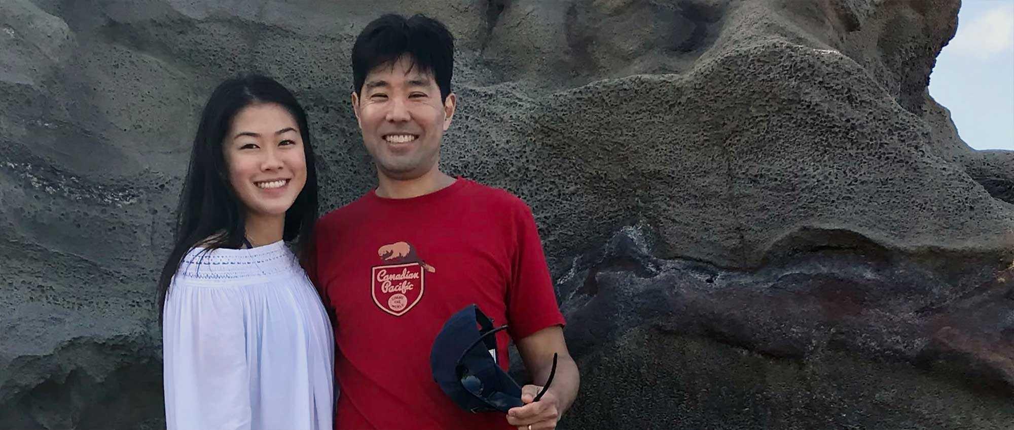 Woman and her father with rocky cliff in background