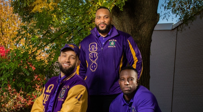 Three members of Lambda Mu Mu together outdoors in fraternity clothing