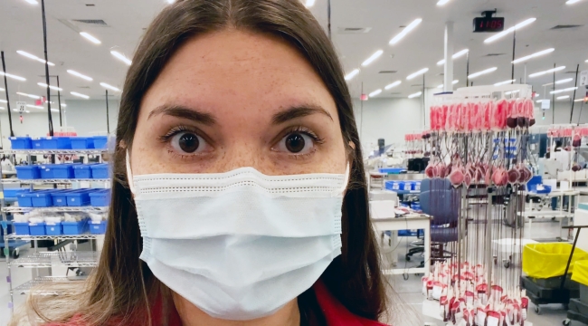 Une docteure en blouse rouge face à un centre de production de sang