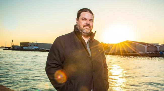 Man at waterfront at sunset on a fall day