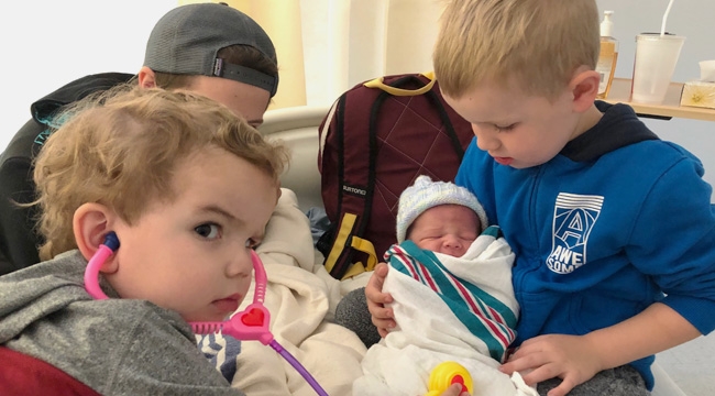 Donavan Does holds his baby brother Evander moments after he was born, as their other brother Austin checks baby’s pulse with a plastic stethoscope. 