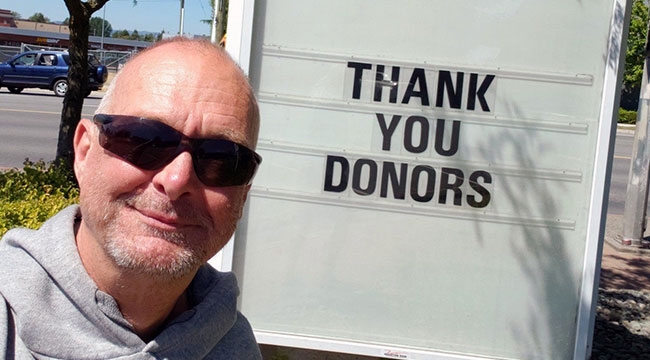 Man in front of sign